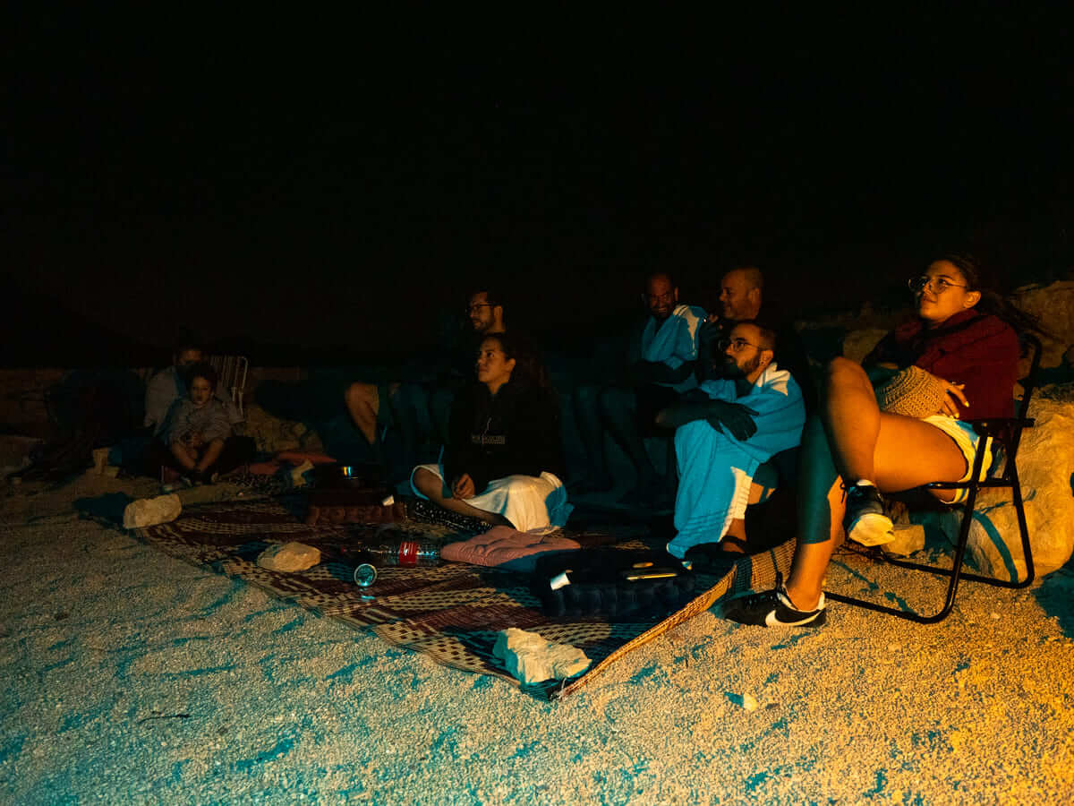 אנשים יושבים במדבר בלילה