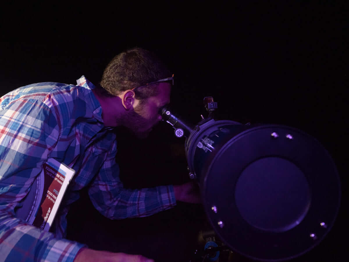 איש מסתכל בטלסקופ