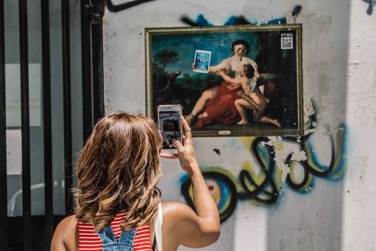 נערה מצלמת גרפיטי בתל אביב