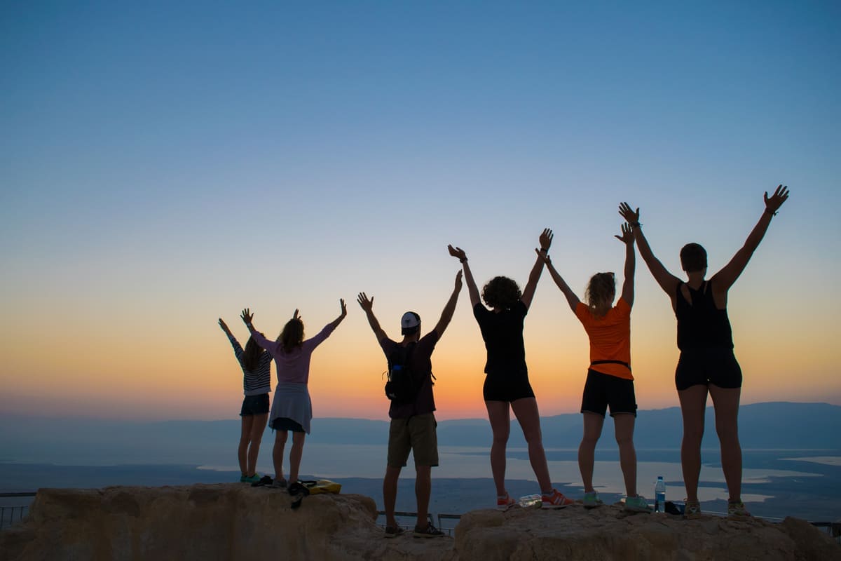 group of people at the sunrise of masada