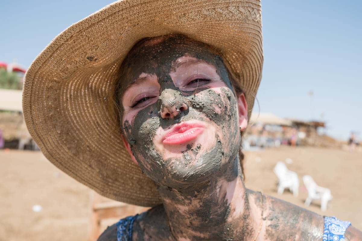 a woman cover with mud at the dead sea