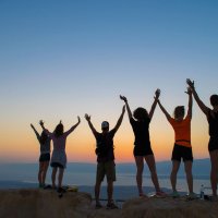 group of people at the sunrise of masada