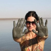 hands fill with mud at the dead sea